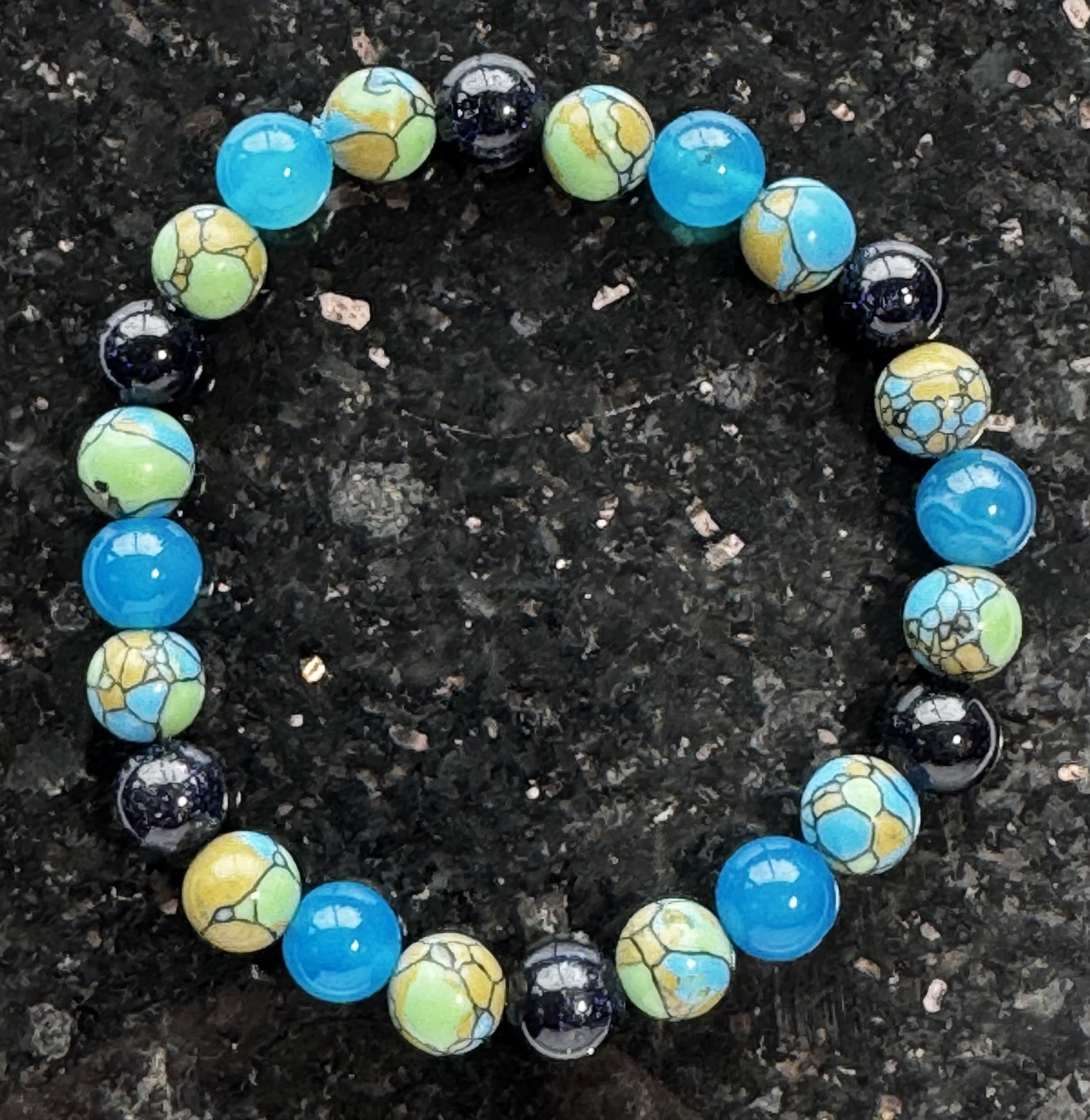 Green and white bracelet with gold scrollwork beads